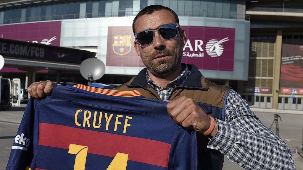 A fan poses with a jersey of late football legend Johan Cruyff outside the Camp Nou stadium in Barcelona yesterday following the death of the Dutch footballer. Photograph: Lluis Genelluis/AFP/Getty