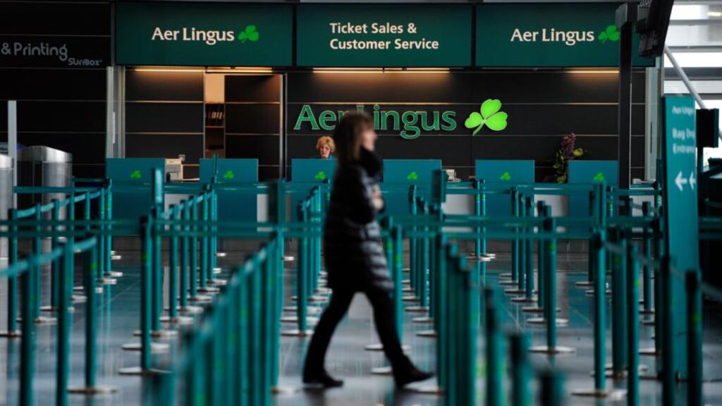 A pedestrian walks past the Aer Lingus ticket and customer services desk in the departure hall at Dublin Airport. Photographer: Aidan Crawley/Bloomberg
