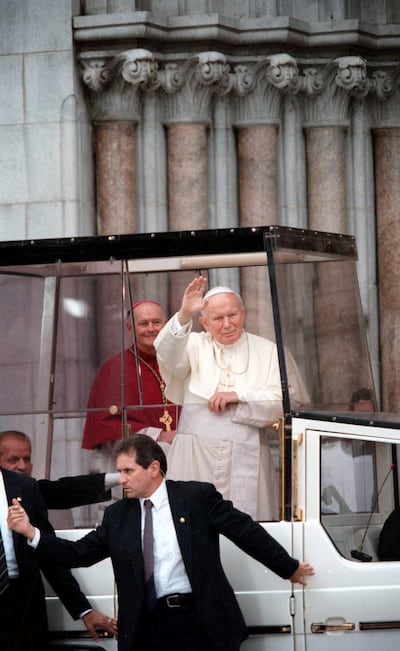Pope John Paul II waves to the crowd as he arrives at the Newark Cathedral in Newark, New Jersey, in October 1995 as then-Cardinal Theodore McCarrick looks on from the background. Photograph: Ozier Muhammad/The New York Times