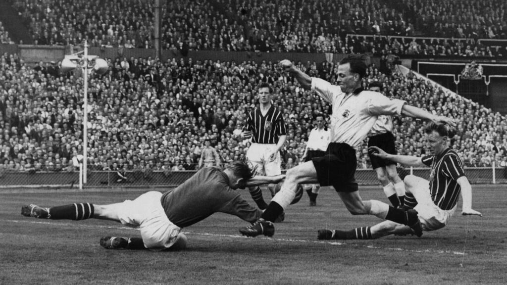 Manchester City’s goalkeeper Bert Trautmann dives at the feet of Birmingham’s Peter Murphy during the 1956 FA Cup Final at Wembley. Trautmann broke his neck making the save, but played on. Photograph:  Allsport Hulton/Archive