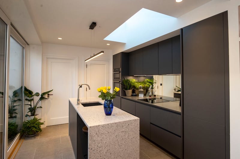 The extension, with its floor to ceiling glazing, contains the couple’s bedroom and bathroom, the kitchen, utility and a family room, and is a modern contemporary space. Photograph: Tom Honan