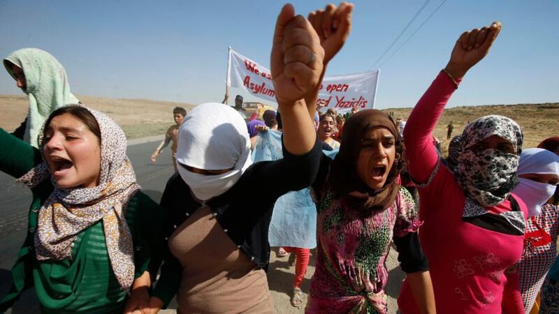 Displaced people from the minority Yazidi sect shout slogans while protesting at the Iraqi-Syrian border crossing in Fishkhabour, Dohuk province, Iraq. They were demanding protection and evacuation from Iraq to safer areas such as Europe and the US. Photograph: Youssef Boudlal/Reuters