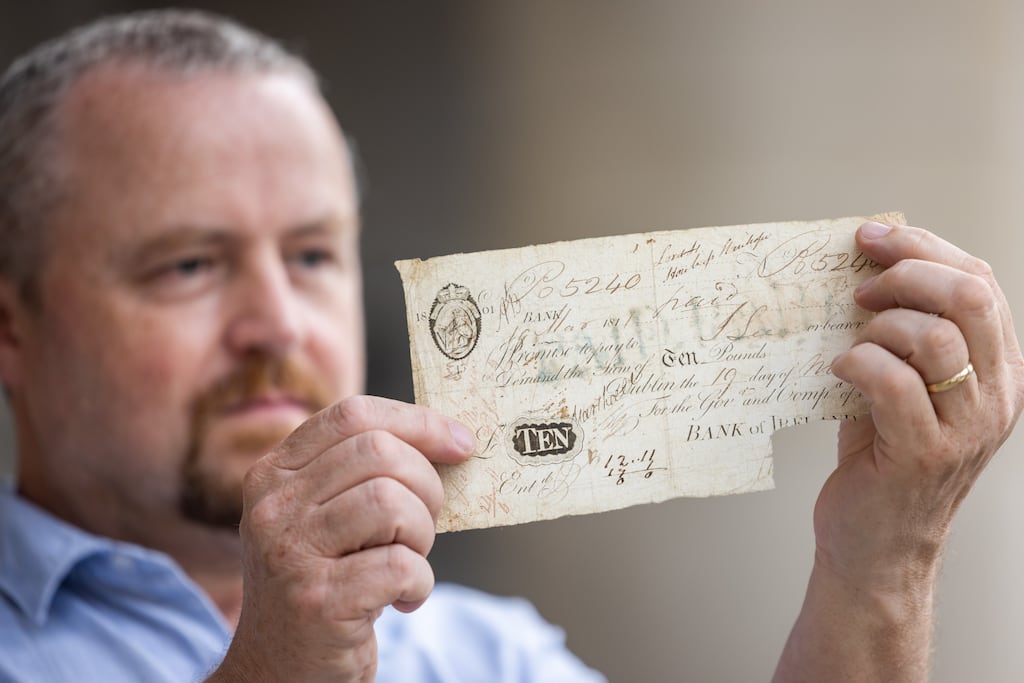 Bank of Ireland historian and author, Mick O’Farrell, with a document from its extensive archive as the bank announced a programme of activities to commemorate its 240th anniversary. Photograph: Naoise Culhane