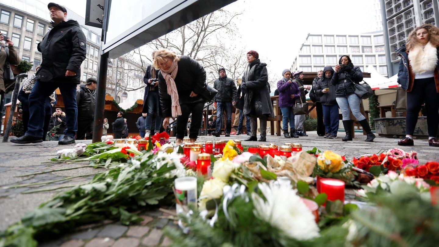 People gather to lay down flowers outside the Gedaechniskirche near the area where a truck which ploughed into a Christmas market. Photograph: Pawel Kopczynski/Reuters