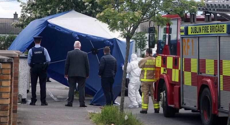 SCENE OF CRIME: Garda, fire and forensics personnel protect the scene after a fatal daytime shooting on Kilbarron Road in Coolock, Dublin, where another man shot dead recently, Sean Little, had lived. Photograph: Padraig O'Reilly