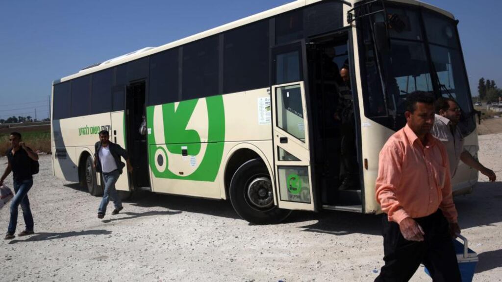 Palestinian workers disembark from an Israeli bus at the Eyal crossing near the West Bank town of Qalqilya on Wednesday. Photograph: AFP Photo/Menahem Kahana