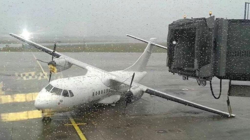 An Aer Lingus Regional commuter plane rests on its left wingtip after being lifted off the ground in 150km/h winds at Shannon Airport. Photograph: Press 22