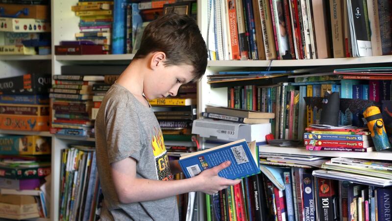 Finn O’Donovan (11) choosing books to read at home in Galway city. Photograph: Joe O’Shaughnessy