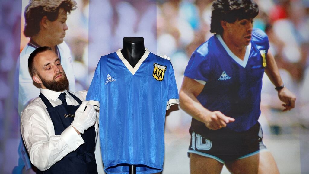 A Sotheby’s assistant with the   shirt worn by Argentina’s Diego Maradona during the  1986 World Cup quarter-final  against England when he scored two famous goals. Photograph: Adrian Dennis/AFP/Getty  Images
