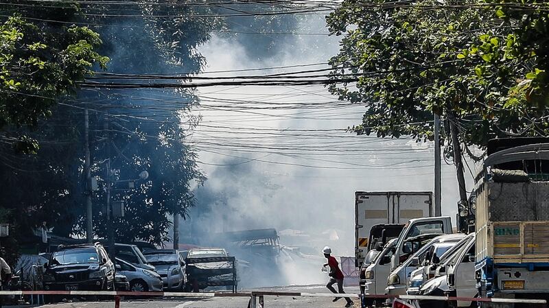 A protester runs after teargas was fired by the police during a protest in Yangon, Myanmar, on Monday. Photograph: EPA