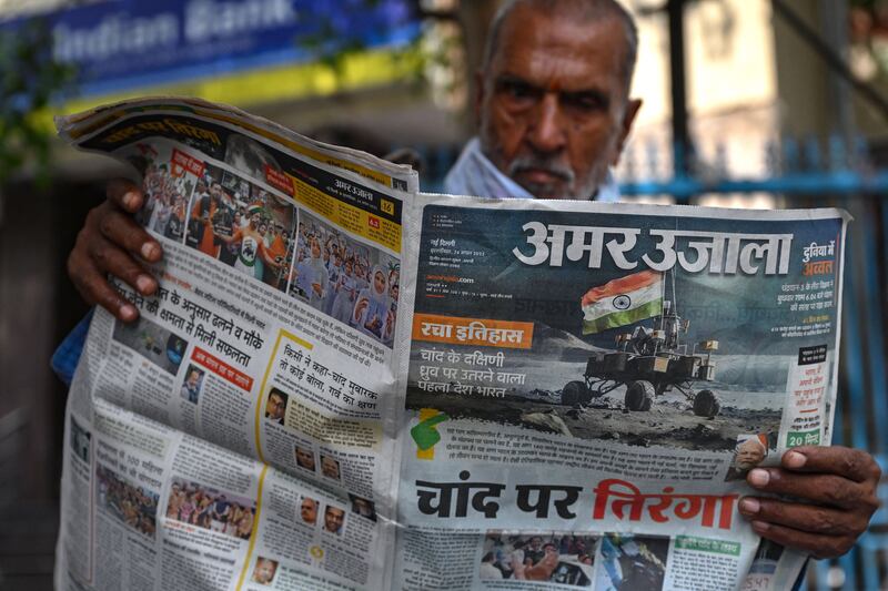 A man reads a daily Hindi newspaper with front page reporting on the successful landing of India's Chandrayaan-3 spacecraft on the south pole of the moon. Photograph: Arun Sankar/AFP via Getty Images