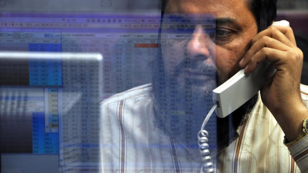 A Pakistani trader monitors shares prices at the Karachi Stock Exchange . Photograph: Shahzaib Akber/EPA