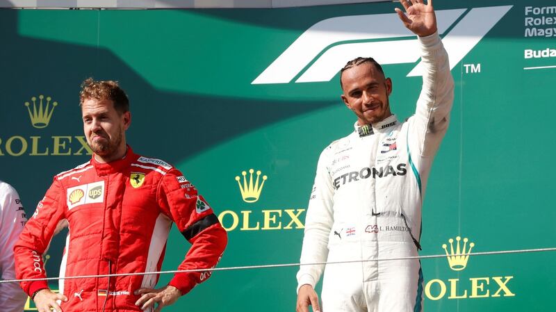 Lewis Hamilton celebrates on the podium alongside second place Sebastian Vettel. Photograph: Bernadett Szabo/Reuters