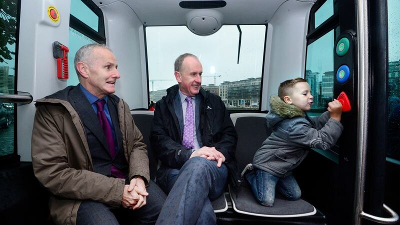 Cllr Ciarán Cuffe and Dublin city chief executive Owen Keegan on the new driverless transport vehicle while Jamie Green of Ashbourne tests the system at Dublin Docks. Photograph: Cyril Byrne