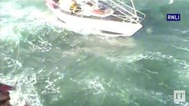 RNLI lifeboat rescue ten-metre yacht with three people on board