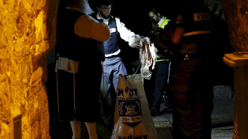A member of the Zaka Rescue and Recovery team  cleans the scene where a Palestinian was shot dead. Photograph: Reuters
