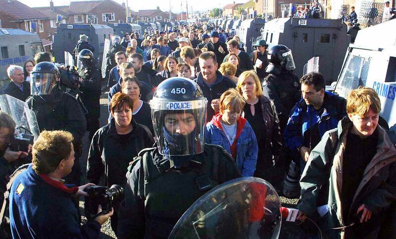Soldiers and police escort Catholic children as they are brought to Holy Cross primary school in September 2001. Photograph: RollingNews.ie