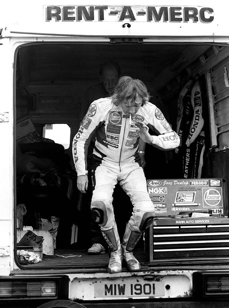 With a cigarette on his lips, Joey Dunlop leaps from his van at the 1994 Skerries 100 races in Co. Dublin.  Photograph: Stephen Davison

