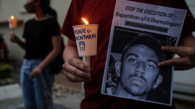 An activist holds a placard with candle during a vigil against the stayed execution of Nagaenthran K Dharmalingam. Photograph: Fazry Ismail/EPA