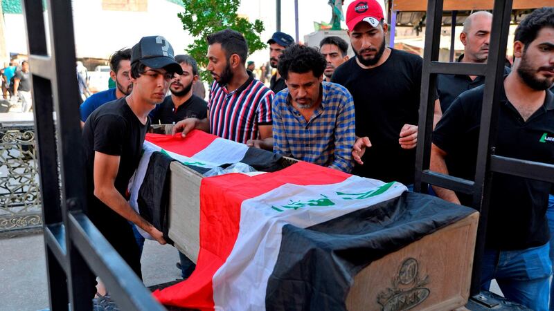 Mourners carry the Iraqi flag-draped coffin of a protester, who was killed amidst clashes in a demonstration, during his funeral in the central Iraqi city of Najaf on Friday. Photograph: Hadir Hamdani/AFP/Getty Images