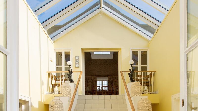 The  front doors  open into a bright entrance hall with a tiled floor and a pitched glass ceiling over tiled stairs to the second floor