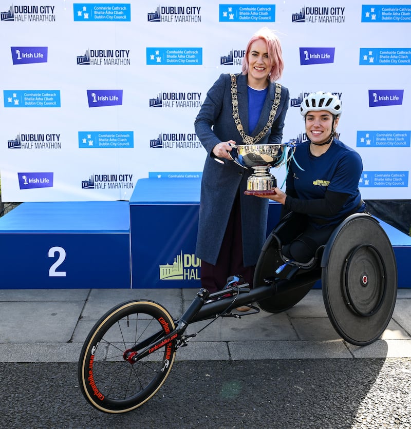 Jade Hall is presented with the women's wheelchair Champion Trophy by the Lord Mayor of Dublin, Cllr Emma Blain. Photograph: Ramsey Cardy/Sportsfile
