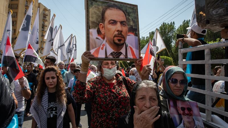 An anti-government protester carries a photograph of the slain activist Ehab Al-Wazni at a demonstration in Baghdad on  October 1st. Photograph: Andrea DiCenzo/New York Times