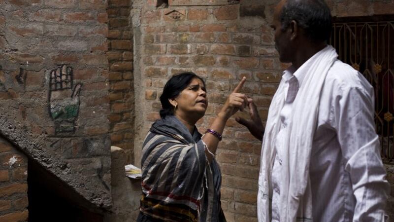 Sampat Pal the founder and national commander of the Gulabi Gang talking with a neighbour. The hand drawn on the wall is the symbol of India’s Congress Party who have courted Sampat to run for political office. Photograph: Carol Ryan
