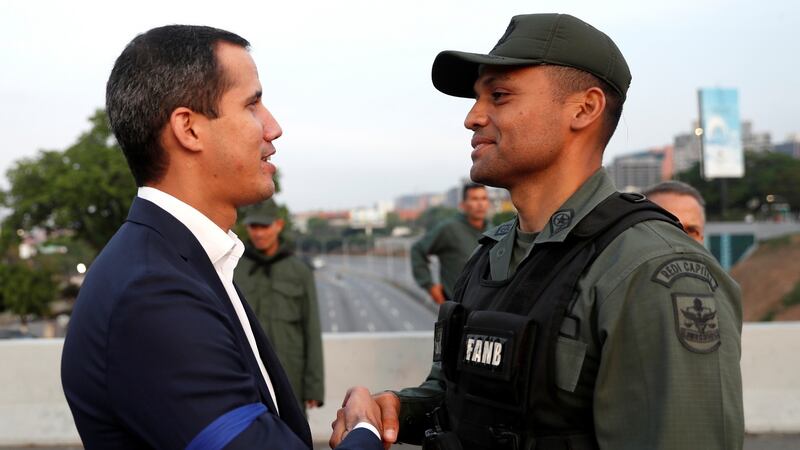 Venezuelan opposition leader Juan Guaidó shakes hands with a military member near the Generalisimo Francisco de Miranda Airbase La Carlota, in Caracas, Venezuela. Photograph: Carlos Garcia Rawlins/Reuters