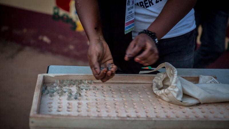 An official counts the number of marbles for a presidential candidate after polls closed in Saturday’s presidential election. Photograph: Sally Hayden