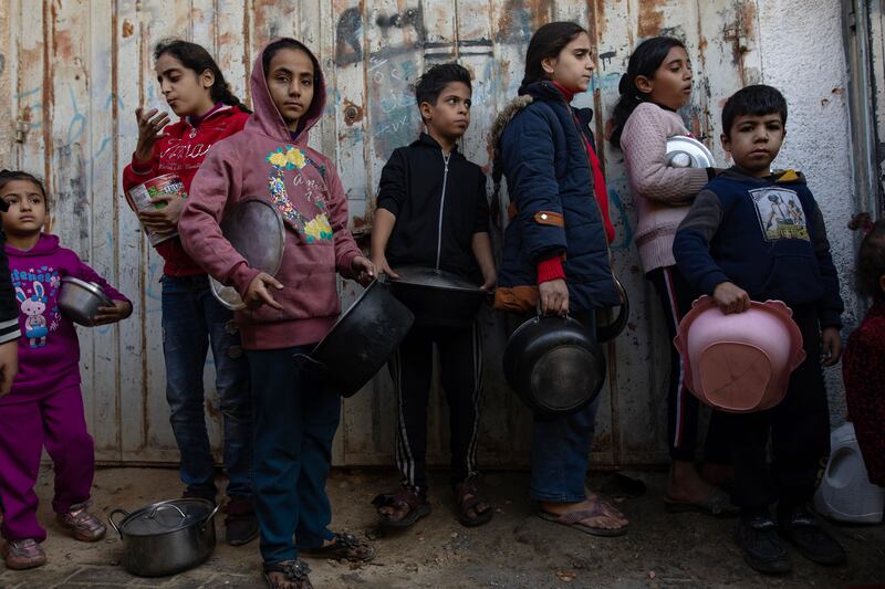 Displaced Palestinian children queue up to receive food distributed by members of a Palestinian youth group in the Khan Younis refugee camp in Gaza on Tuesday. Photograph: Haitham Imad/EPA-EFE