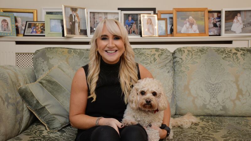 Aileen Hickie,  chief executive  of Parentline,  at home with her dog Scout, with photos of husband Matt Cooper and five children in the backgound. Photograph: Alan Betson