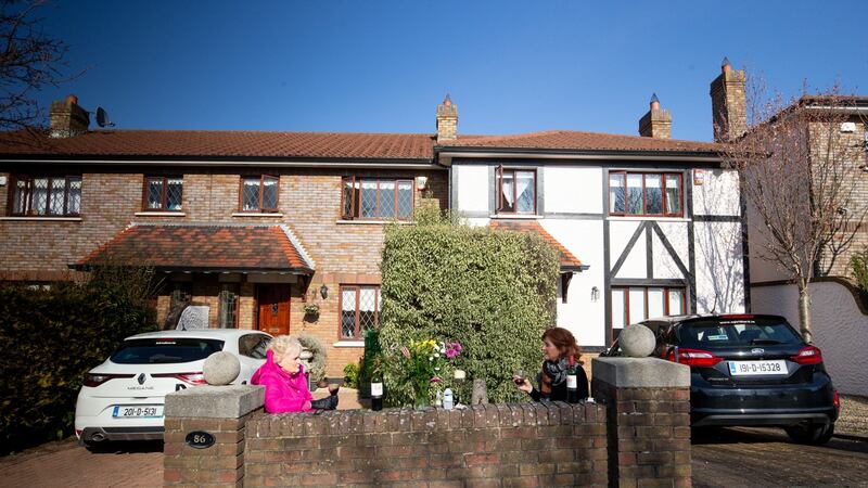 Rosemary Smith sitting drinking wine in her front garden having a socially distant chat with her neighbour Deborah Harpur. Photograph: Tom Honan