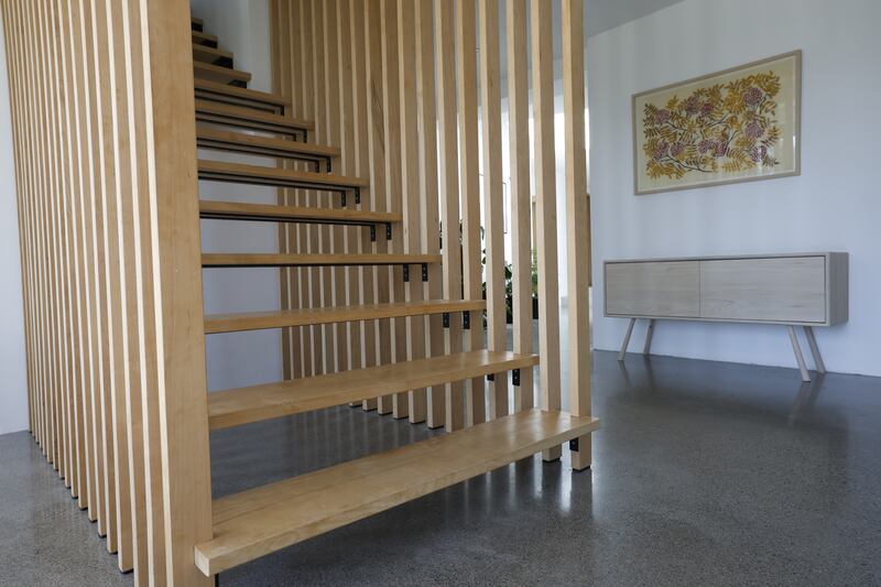 A detail of the open tread staircase with fashionable batten frame.