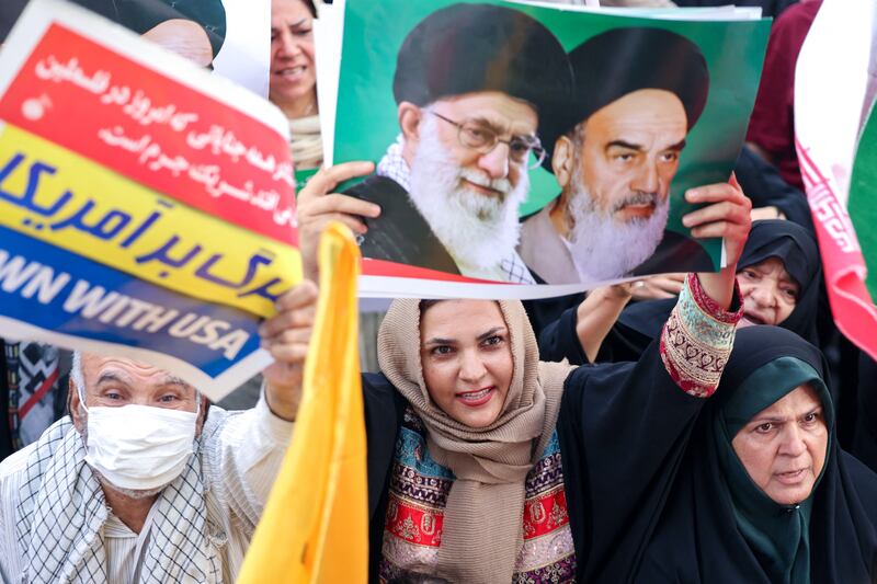 An Iranian woman holds a poster with portraits of Iranian supreme leader Ayatollah Ali Khamenei and late supreme leader Ayatollah Ruhollah Khomeini as people celebrate a ceasefire between Iran and Israel in the capital Tehran. Photograph: Atta Kenare/AFP via Getty   