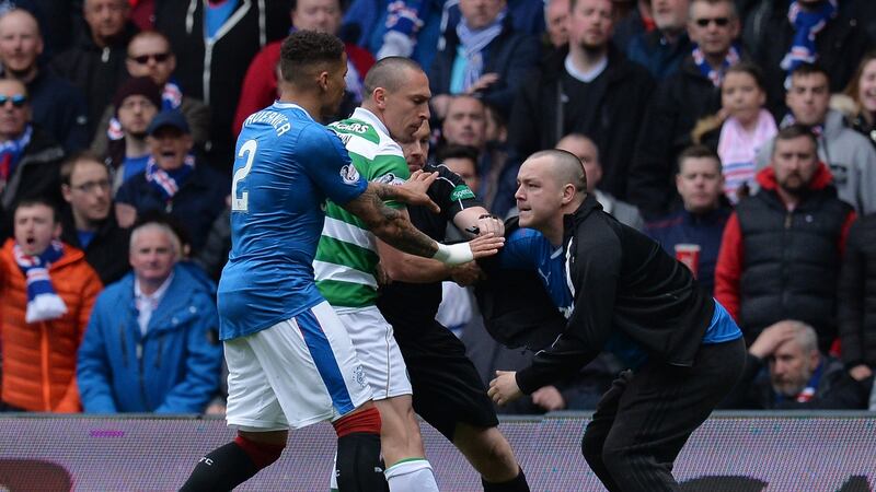 A pitch invader comes on to the pitch and approaches Celtic captain Scott Brown. Photograph: Mark Runnacles/Getty Images