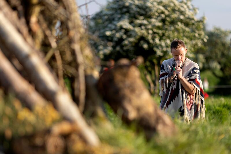 Pawel Naszczyniec pauses in front the unlit bonfire pile after leaving an offering to 'let go of bad experiences'