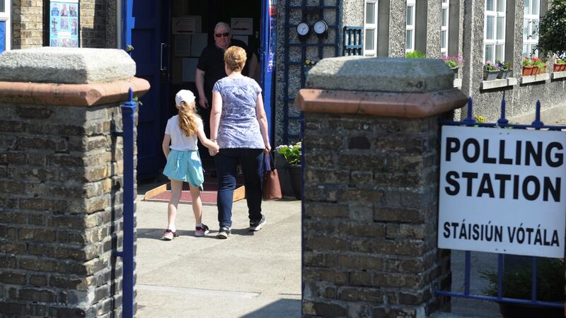 A woman and  child enter a polling station in Dublin as voting in the referendum on the Eighth Amendment proceeds. Photograph: Aidan Crawley/EPA