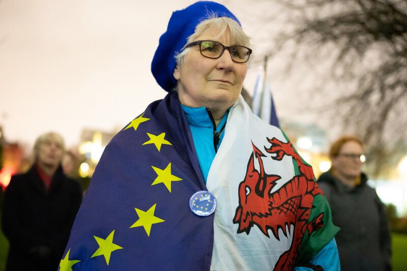 A woman wrapped in an EU flag and a Welsh flag looks on during a candlelight vigil in support of remaining in the European Union on January 31st, 2020, in Cardiff. Photograph: Matthew Horwood/Getty Images