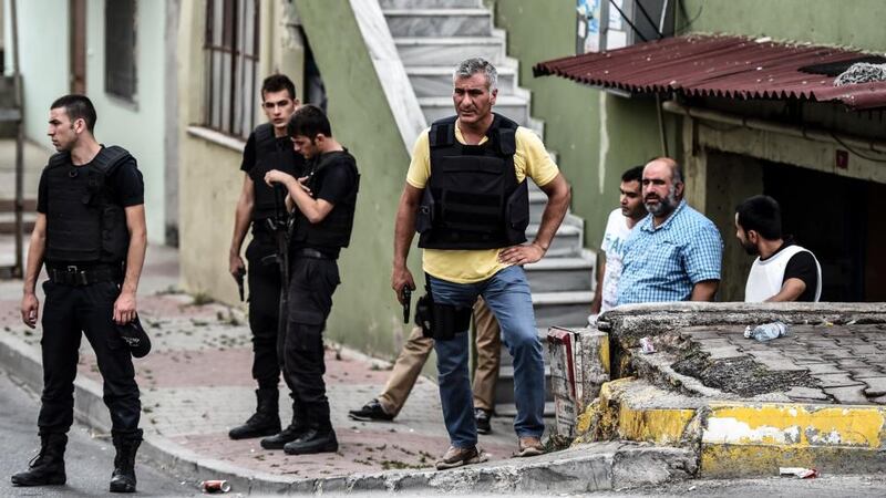 Plain clothes police officers take position with guns during clashes with attackers at the Sultanbeyli district in Istanbul. Photograph:  Ozan Kose/AFP/Getty Images.