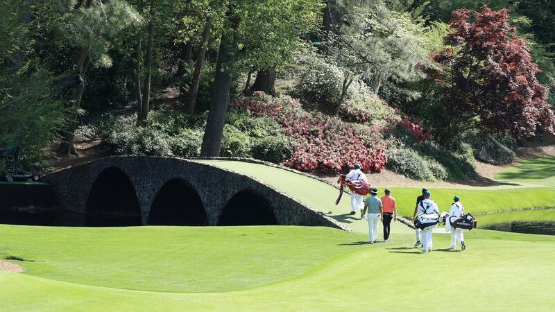 Finau, Bernhard Langer and Yuta Ikeda cross the Hogan Bridge to the 12th green. Photo: Andrew Redington/Getty Images