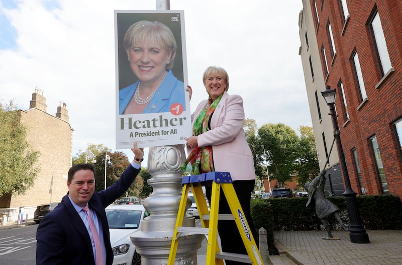 Heather Humphreys putting a poster on a pole on Mount Street, Dublin, assisted by Martin Heydon. Photograph: Alan Betson