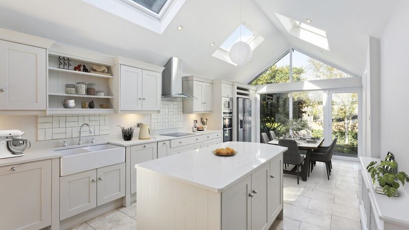 The pale grey kitchen opens on to the garden