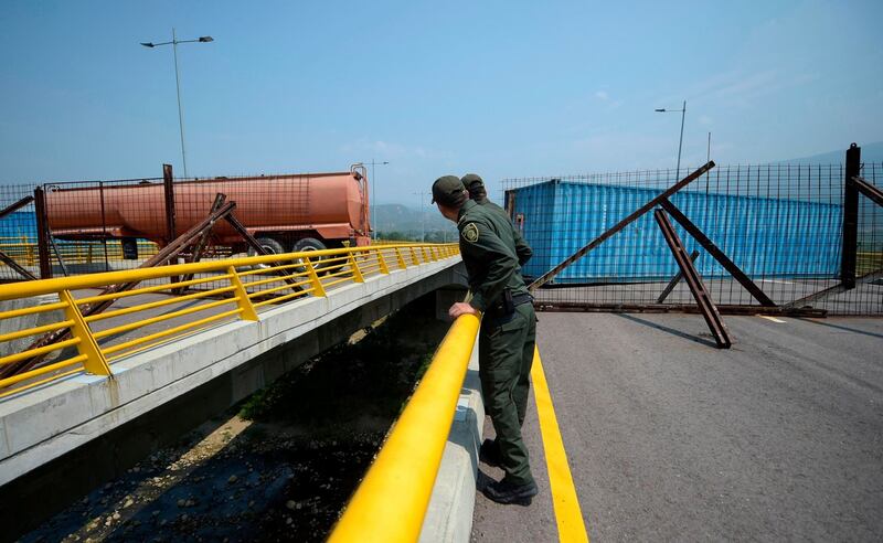 Colombian policemen look at the barricade on the Tienditas Bridge Photograph: Raul Arboleda/AFP/Getty