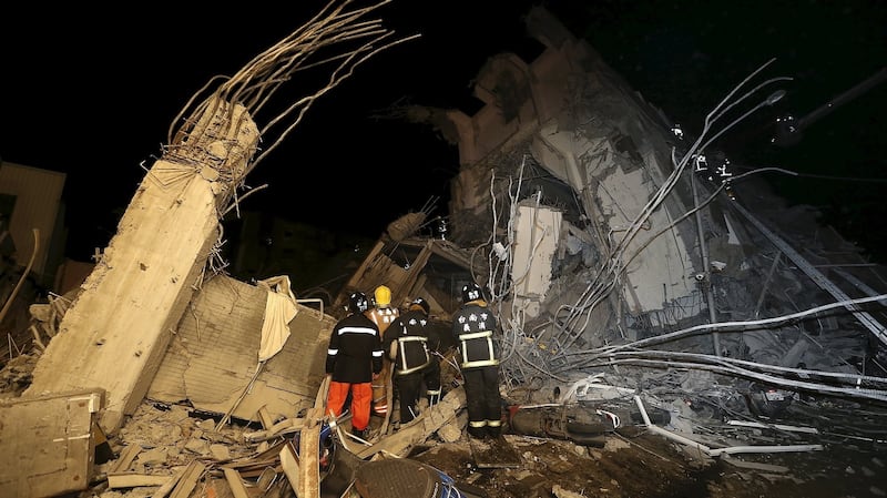 Rescue personnel  search through a damaged building following an  earthquake in Tainan, southern Taiwan. Photograph: Stringer/Reuters