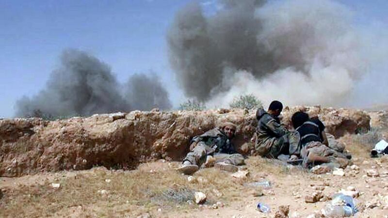 Islamic State fighters take cover during a battle against Syrian government forces on a road between Homs and Palmyra, Syria. Photograph: AP