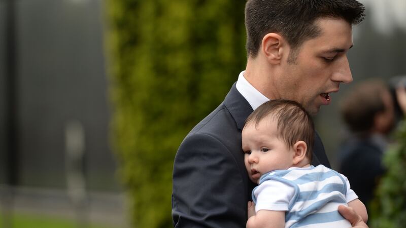 Niall Casement  with his baby Thomas at Glasnevin Cemetery for the centenary ceremony to commemorate the execution of his relative Roger Casement. Photograph: Dara Mac Dónaill