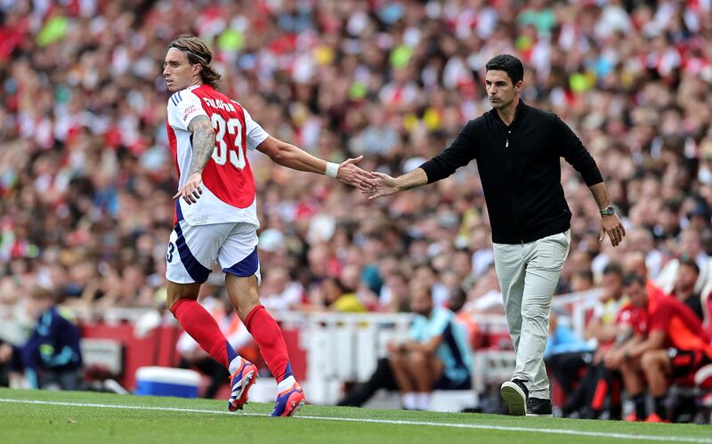 Riccardo Calafiori of Arsenal touches hands with Arsenal manager Mikel Arteta. Photograph: David Rogers/Getty