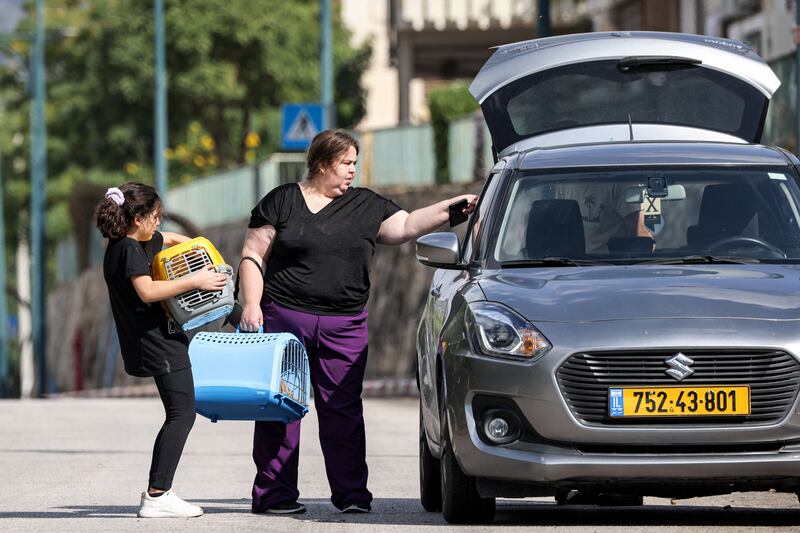 A woman and a girl hold pet carriers and other belongings as they prepare to depart from Kiryat Shmona in northern Israel, as part of an evacuation in the area. Photograph: Jalaa Marey/Getty Images/AFP