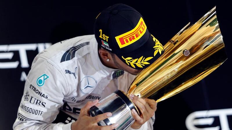 Lewis Hamilton of Britain celebrates on the podium after winning the Abu Dhabi F1 Grand Prix and the F1 Championship at the Yas Marina circuit in Abu Dhabi. Photograph: Ahmed Jadallah / Reuters